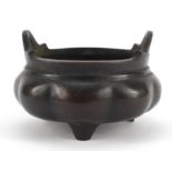 Chinese patinated bronze tripod incense burner with twin handles, character marks to the base,