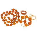 Two butterscotch amber coloured bead necklaces and ring, the largest necklace 50cm in length, 58.