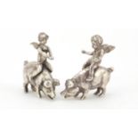 Pair of miniature unmarked silver figures of Putti riding a pig, the largest 4cm high, 43.0g :For