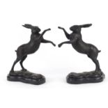 Matched pair of patinated bronze hares raised on shaped black marbles bases, each 30cm high :For