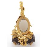 French Empire style gilt bronze table mirror in the form of putti with a mandolin, raised on a