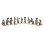 Eleven German porcelain monkey band figures in the style of Meissen, each with blue under glaze