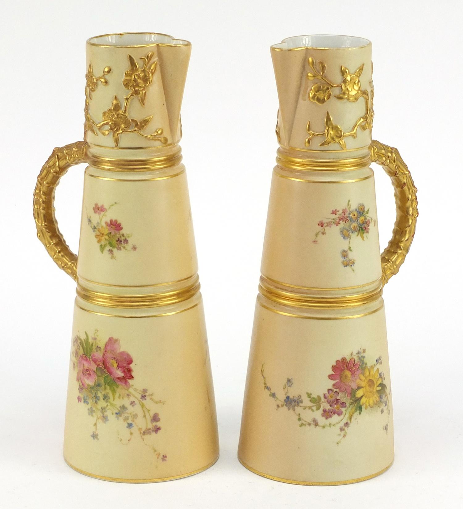 Pair of Royal Worcester blush ivory jugs with tapering bodies, each hand painted and gilded with