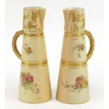 Pair of Royal Worcester blush ivory jugs with tapering bodies, each hand painted and gilded with