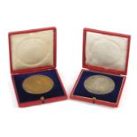 Two commemorative medallions with velvet lined tooled leather cases, comprising silver Victorian