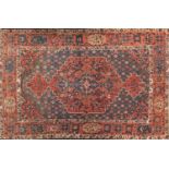 Rectangular Persian rug having an all over floral design onto a red and blue grounds, 216cm x