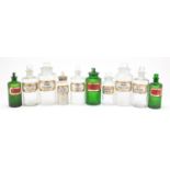 Antique glass apothecary jars with labels including three green examples, the largest 22cm high :