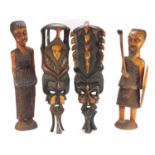 Four tribal wood carvings including a tribesman and two face masks, the largest 60cm high : For