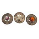 Three Scottish silver thistle brooches, two set with colourful stones, the largest 4.5cm in