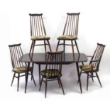 Ercol elm extending dining table with five stick back chairs and leaf, the table 71cm H x 152cm W