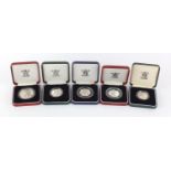 Five silver proof coins with cases comprising two fifty pence pieces, two two pound coins and a