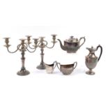 Silver plated items including a three piece teaset and pair of two branch candelabras, the largest