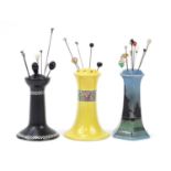 Three porcelain hatpin stands and a selection of vintage hatpins, the largest stand 13.5cm high :