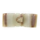 Chinese russet and pale green jade two piece buckle carved with a lion's head, overall 8.5cm x 3.5cm