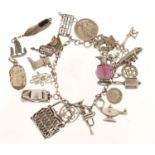 Silver charm bracelet with a large selection of mostly silver charms, including a scarab beetle,