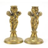 Pair of classical bronzed candlesticks with Putti columns, each 24cm high : For Further Condition