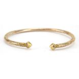 Unmarked gold bangle, (tests as 9ct gold) engraved with flowers, 7cm wide, 21.8g : For Further