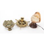 Carved conch shell lamp, brass door knocker and Ships wheel design ashtray, the largest 16cm