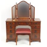 Mahogany dressing table with footstool and a folding triple aspect mirror, the dressing table 77cm H