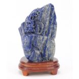 Large Chinese lapis lazuli fragment carved with a figure amongst mountains beside a tree raised on a