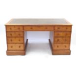Edwardian oak twin pedestal desk by James Winter & Sons, having a tooled leather insert and
