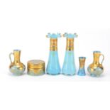 French blue opaque glassware gilded with flowers including a pot and cover and pair of vases, the