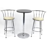 Adjustable pedestal table and two chromed breakfast stools with cream faux leather seats, the