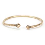 Unmarked gold bangle, (tests as 9ct gold) engraved with flowers, 7cm wide, 23.2g : For Further