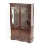 Mahogany display cabinet fitted with a pair of glazed doors enclosing two glass shelves above a pair