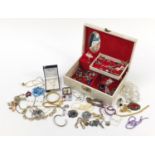 Vintage and later costume jewellery arranged in a musical jewellery box including brooches and