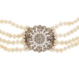 Four row pearl necklace with a large unmarked white metal diamond set clasp, 40cm in length, the