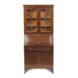 Arts & Crafts oak bureau bookcase fitted with a pair of leaded glass doors above a fall, freize