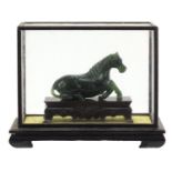 Chinese green horse, possibly hardstone, housed in a glazed case, overall 17cm H x 21cm W x 11cm D :