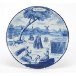 Antique Delft pottery plate entitled Augustus, hand painted with two figures with dog before a field