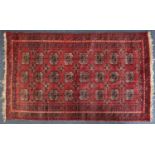 Rectangular Persian rug having an all over floral design onto a red ground, 169cm x 99cm : For