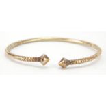 Unmarked gold bangle, (tests as 9ct gold) engraved with flowers, 7cm wide, 22.2g : For Further