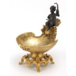 Partially gilt bronze sweetmeat dish in the form of Putti seated on a shell above a bowl,