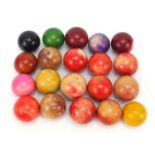 Twenty antique stained ivory billiard balls, the largest approximately 5.2cm in diameter : For