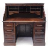 Oak tambour front roll top desk with eight drawers, 75.5cm and 50.5cm H x 126cm W x 75.5cm D : For