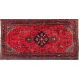 Hand made Iranian rug decorated with floral pattern onto a red and blue ground, 240cm x 126cm :