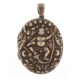 Indian silver oval locket, embossed with a dancing figure and animals, 6.2cm in length, 3.1g : For