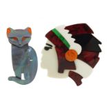 Two Lea Stein style brooches in the form of a Native American's head and a stylised cat, the largest