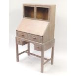 Art Deco limed oak bureau with twin door glazed cabinet top, having two drawers above two shorter