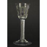 18th century Jacobite wine glass having a rounded funnel bowl engraved with a rose and foliage, on