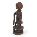 African tribal interest carved wood squatting Chamber figure wearing an iron necklace, 39cm high :