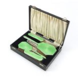 Art Deco five piece green giulloche enamel vanity set with fitted case comprising four brushes and a