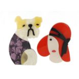 Two Lea Stein style brooches in the form of a seated dog and a Art Deco lady wearing a hat, the