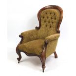 Victorian walnut spoon back arm chair with floral carved top rail and brown button back