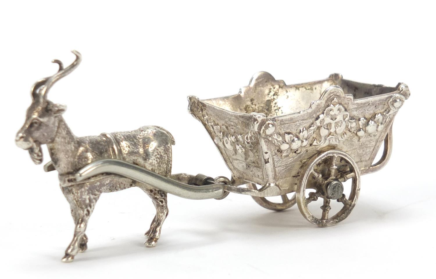 German silver model of goat pulling a cart with rotating wheels, impressed to the base, 11cm in