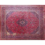 Rectangular Persian Kashan carpet with floral pattern onto a red and blue ground, 377cm x 295cm :